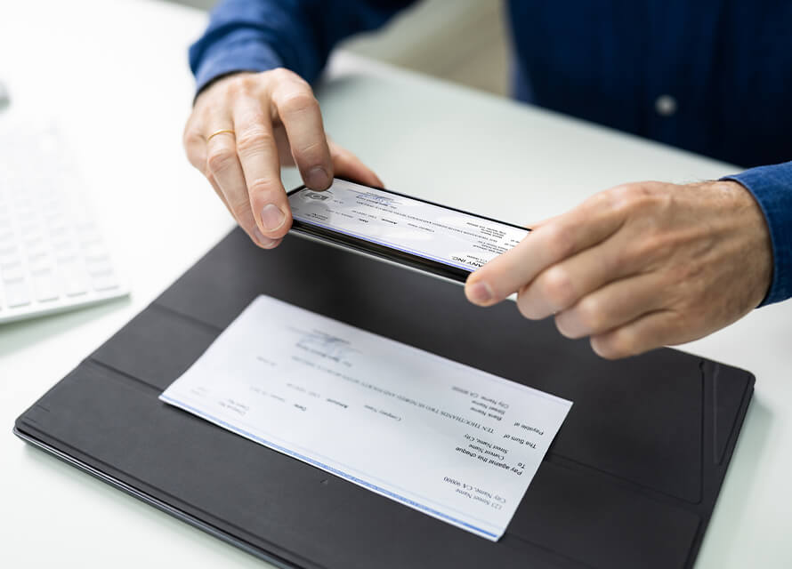 Person depositing a check via smartphone, highlighting the secure and convenient features of a digital banking platform with mobile RDC.
