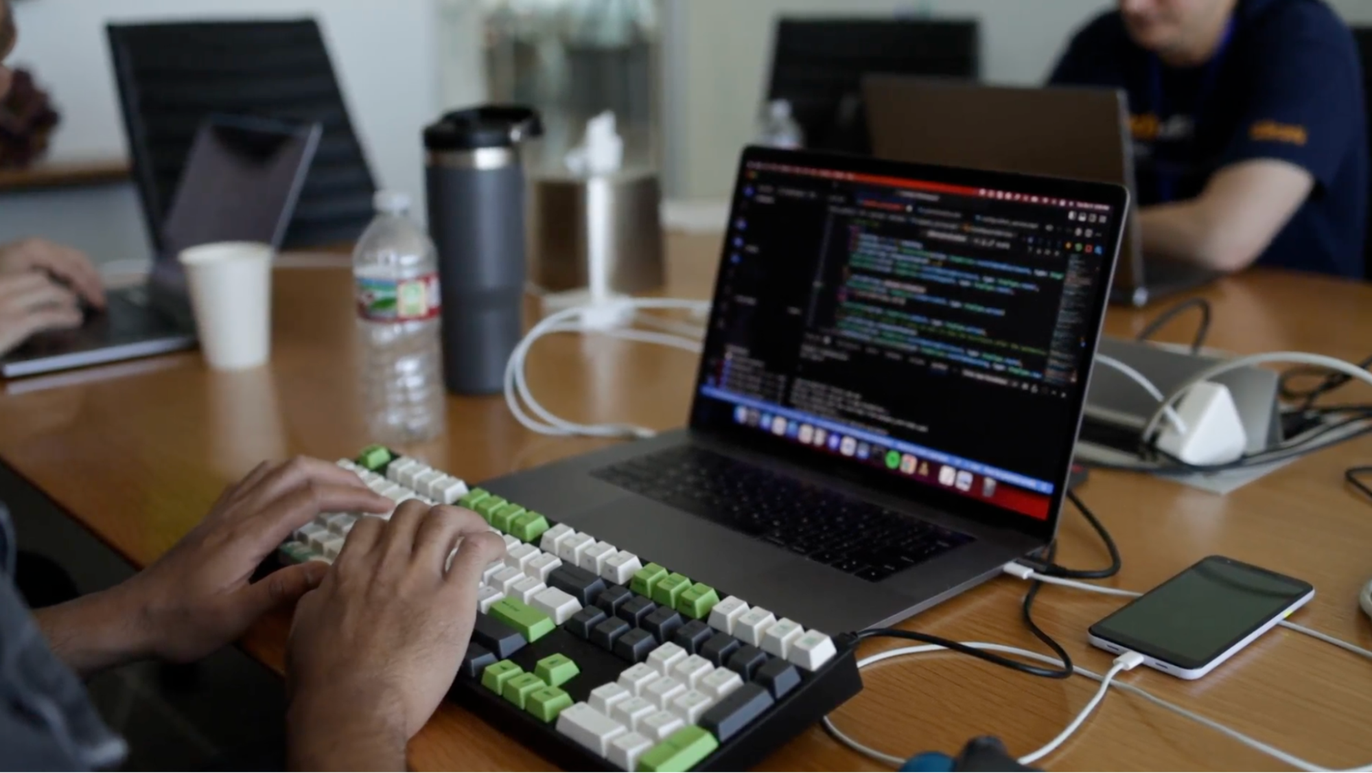 Developer typing on a laptop, focused on coding and building banking solutions during a hackathon with teammates