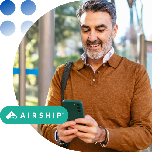 Middle-aged man in a brown sweater uses his smartphone outdoors, with an Airship logo badge in the corner.