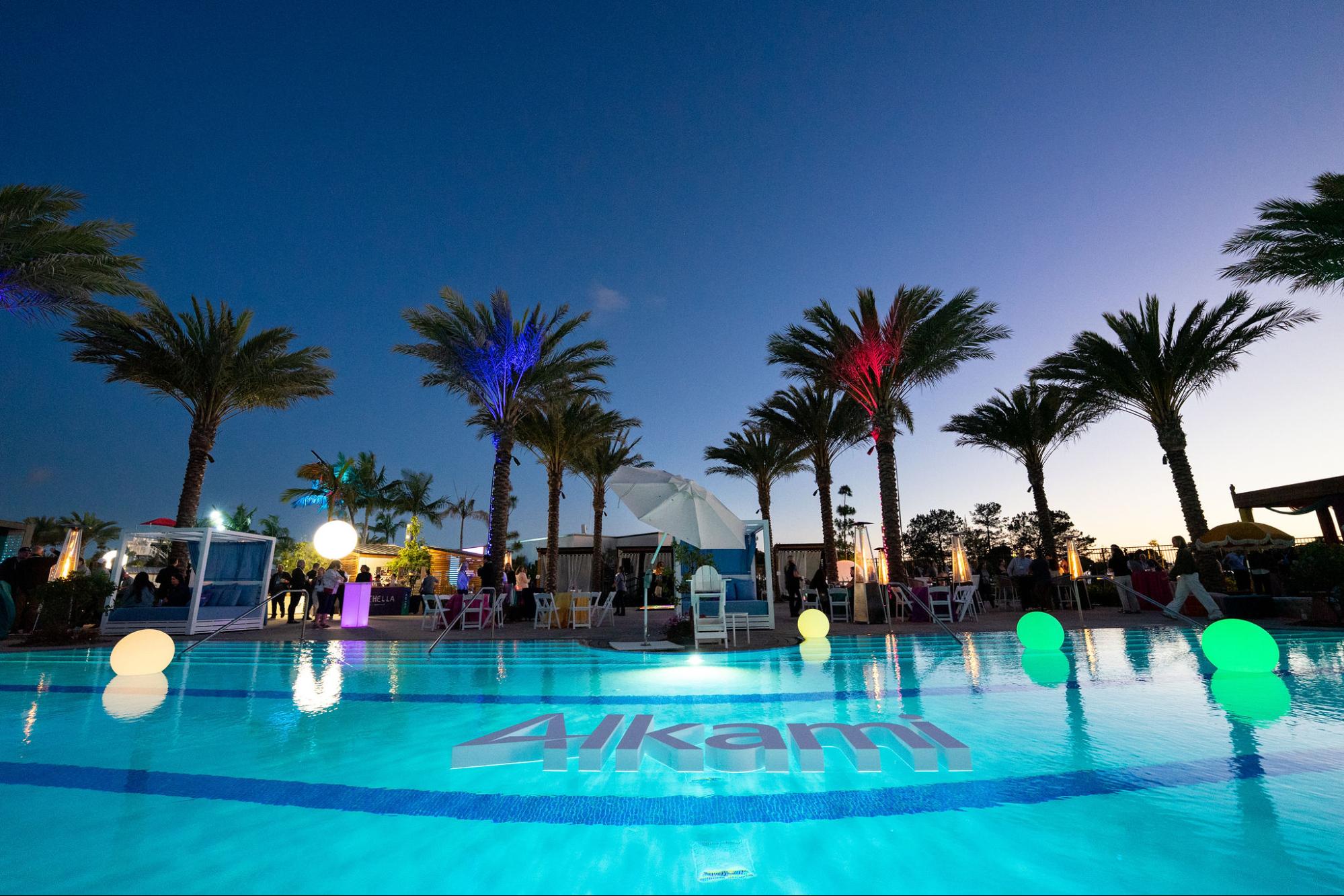 gaylord-2026 - Alkami Technology Poolside of the Gaylord Pacific, palm trees, colorful lights, and the Alkami logo floating in the pool