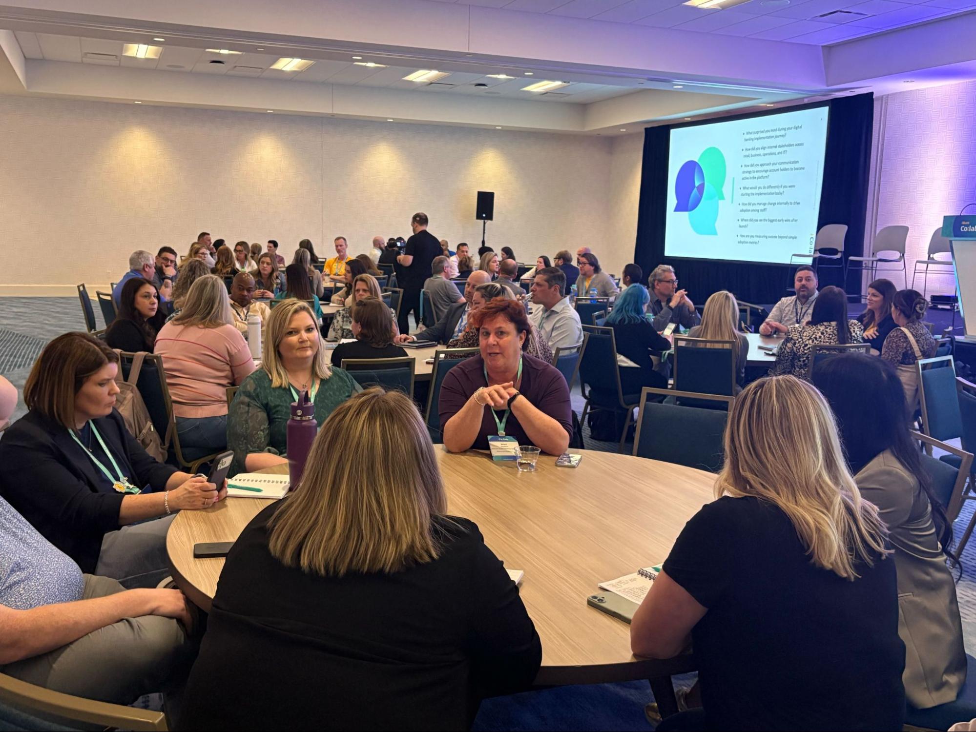 Attendees participate in a roundtable discussion focused on digital banking implementation for business and retail financial services.