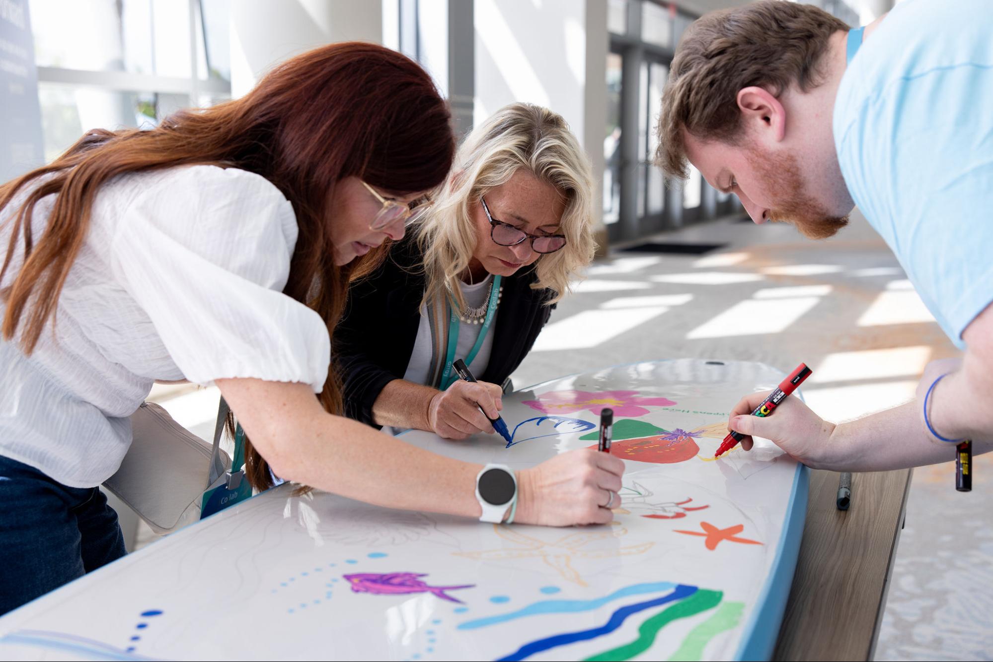 surfboard-paint - Alkami Technology Alkami Co:lab attendees painting surfboards together