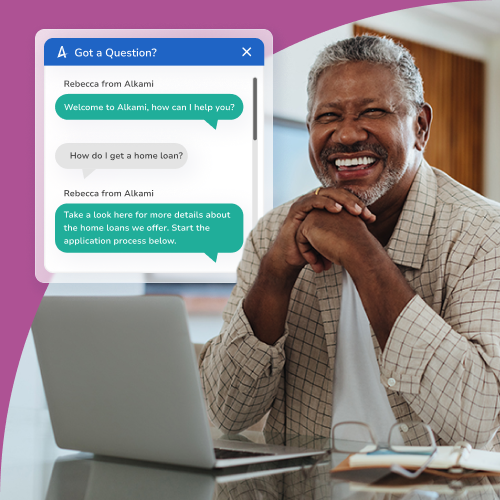 Smiling man at a desk with a laptop and a floating chat-support window showing a friendly help conversation.