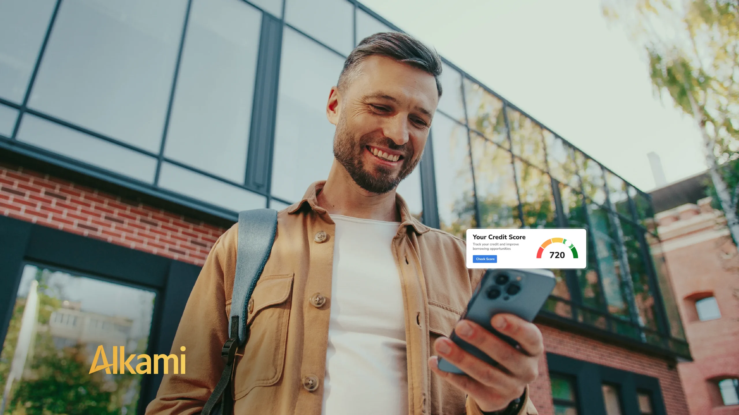 Man outdoors looking at smartphone with a credit score widget overlay on the screen, smiling as he checks his score near a modern glass building.